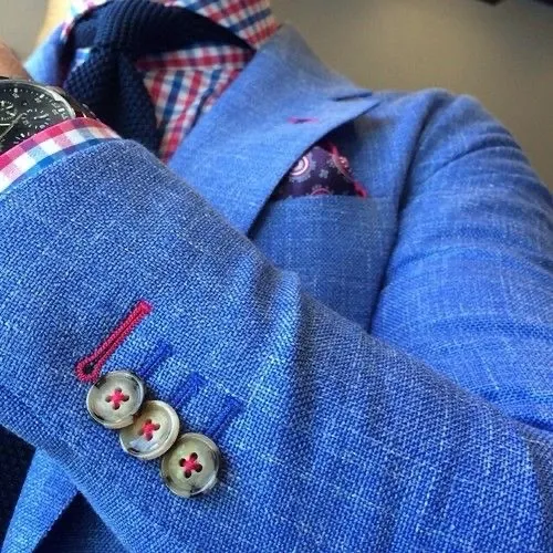 Blue linen suit with red contrast stitching and knit tie showing accessories completing the belt look.