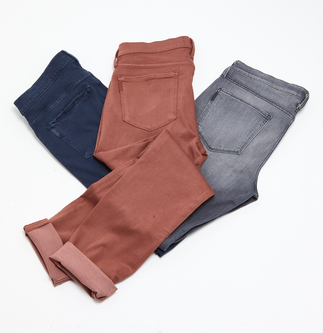 Three pairs of tailored trousers in navy, terracotta, and grey showing color options for sport jacket outfits