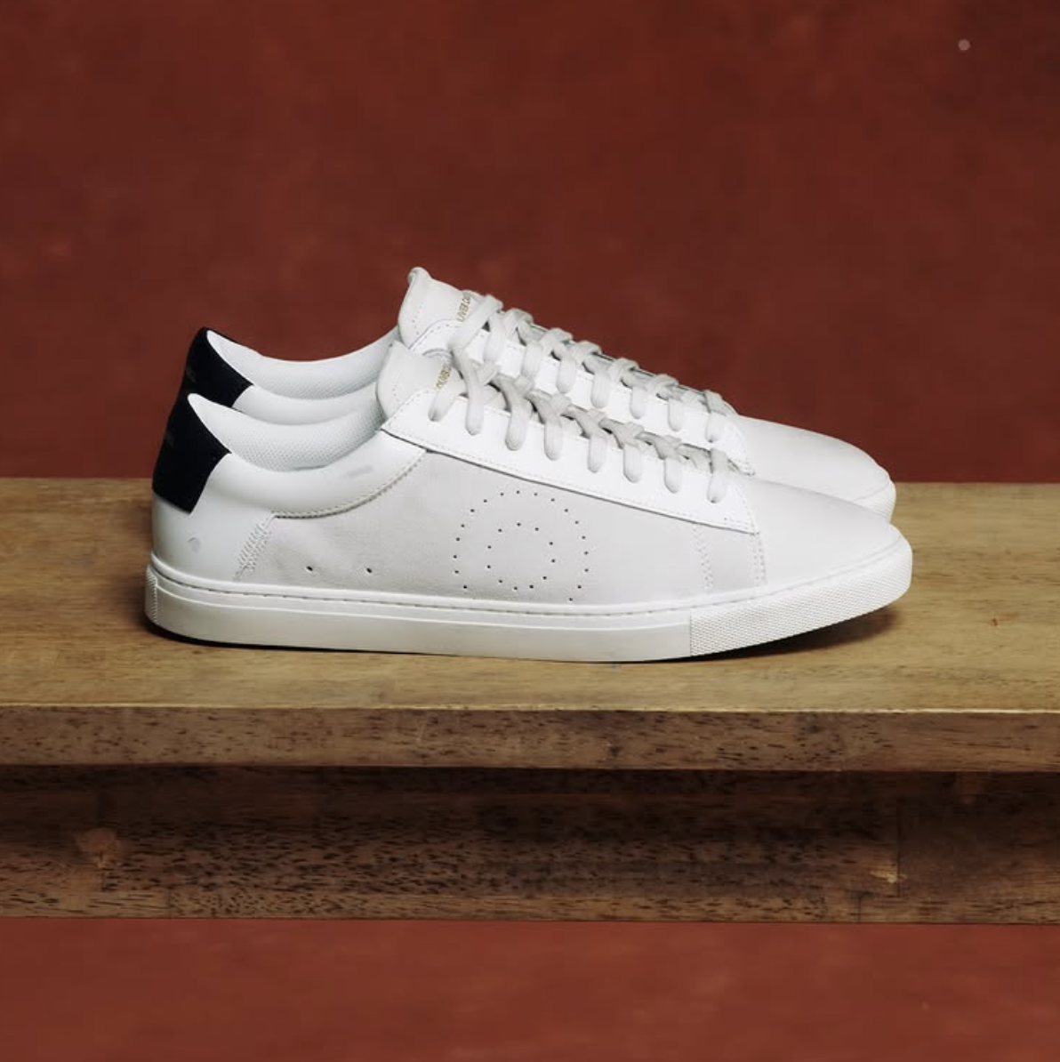 Oliver Cabell Low 1 white leather sneakers with Margom sole on wooden surface, showcasing Italian calfskin leather craftsmanship.
