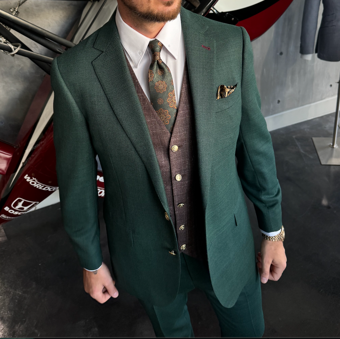 Man wearing a dark green bespoke suit at a Miami social event