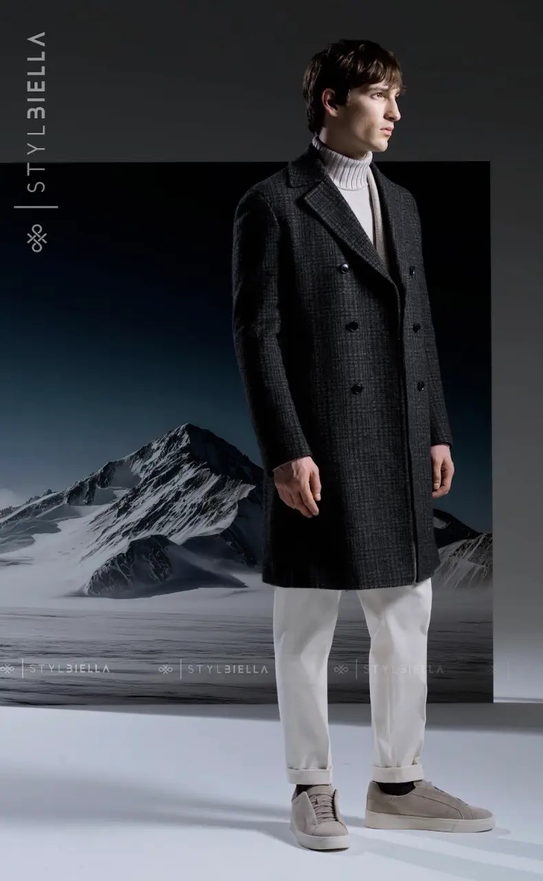 Charcoal micro-check double-breasted overcoat with grey turtleneck and white trousers in mountain setting