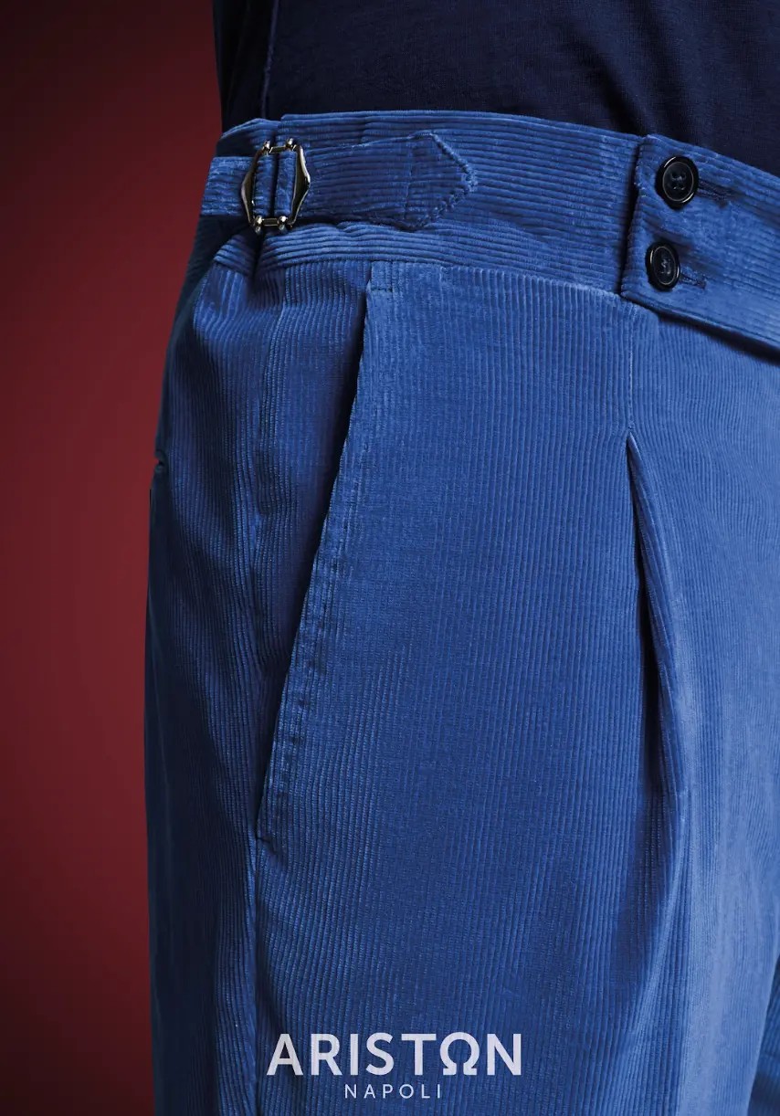 Royal blue medium-wale corduroy trousers with double button closure and side adjusters worn with navy knit shirt