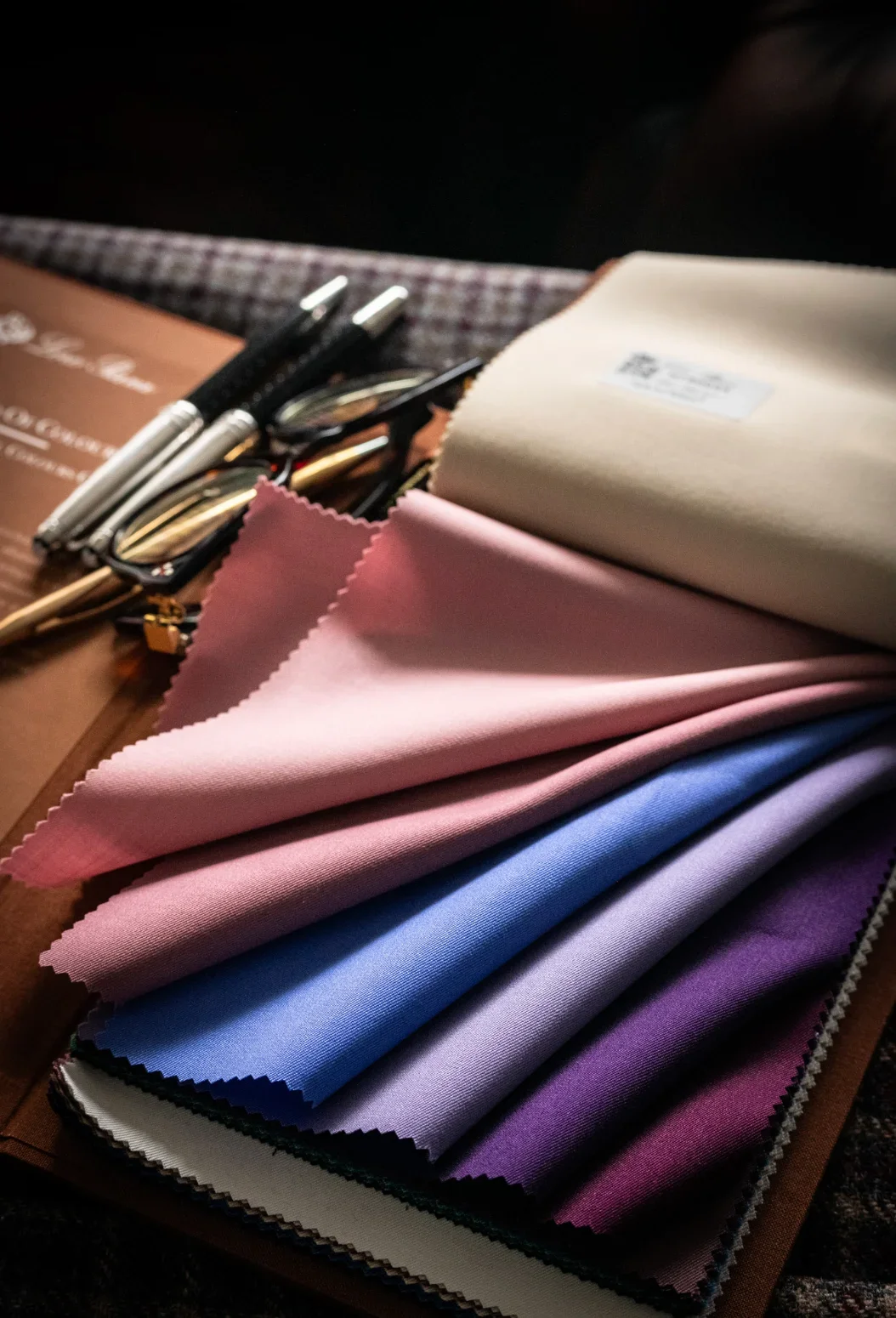 Close Up Of Premium Suit Fabric Swatches In Navy, Charcoal, And Grey At The Bespoke Cb Showroom custom menswear detail by.