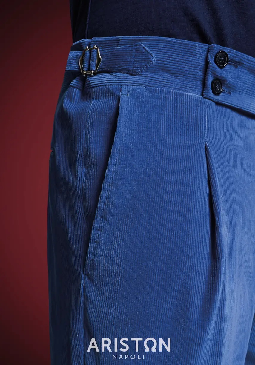 Royal blue medium-wale corduroy trousers with double button closure and side adjusters worn with navy knit shirt