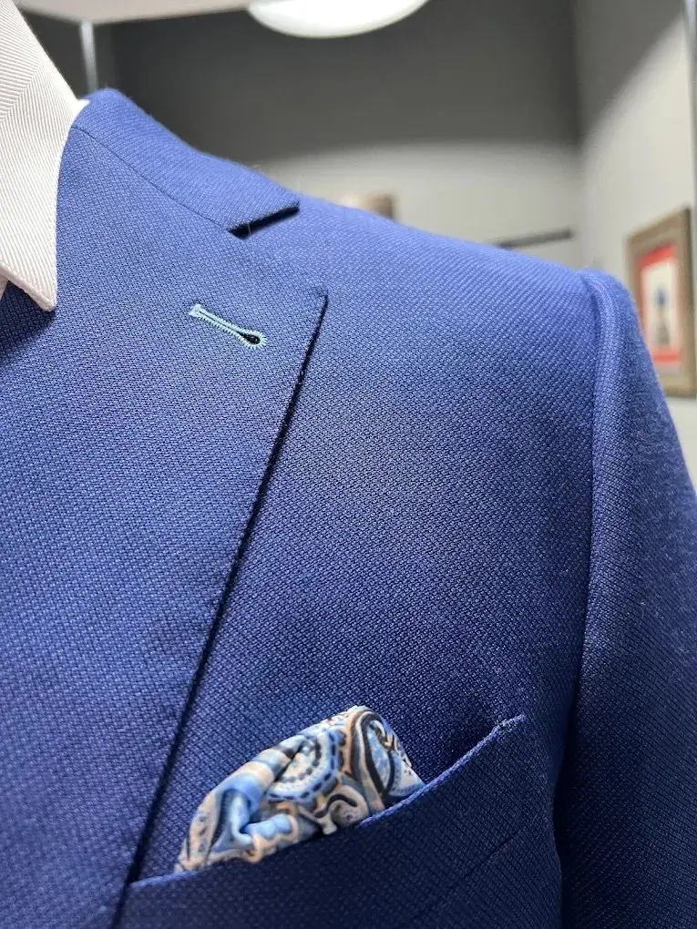 Navy custom blazer with peak lapel and patterned pocket square for professional wear