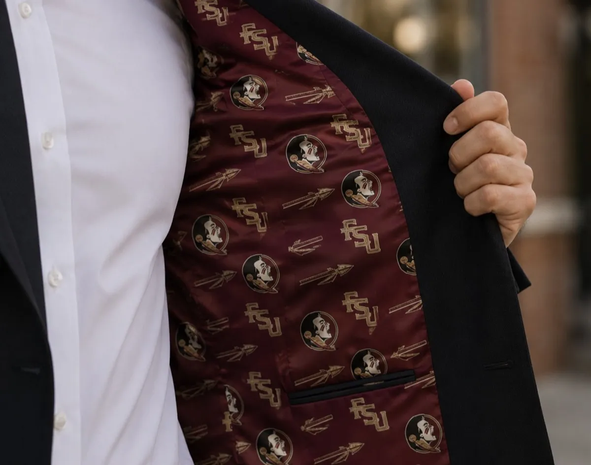 Black suit jacket held open to reveal a garnet satin interior lining featuring Florida State University FSU logos, gold Seminole head emblems, and crossed arrow motifs, crafted by Bespoke By CB.