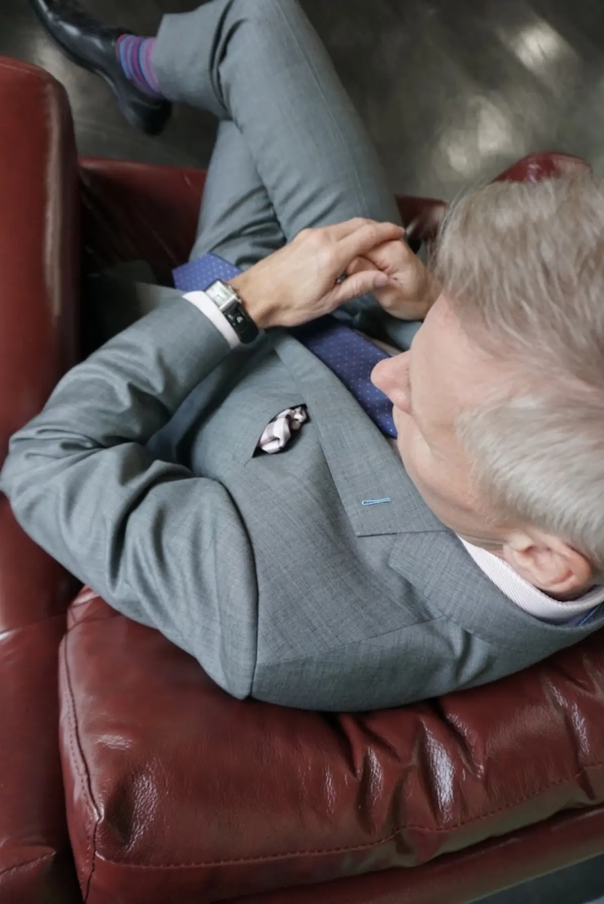A man wearing a medium grey custom tailored suit demonstrates the quality and fit you get when investing in custom clothing