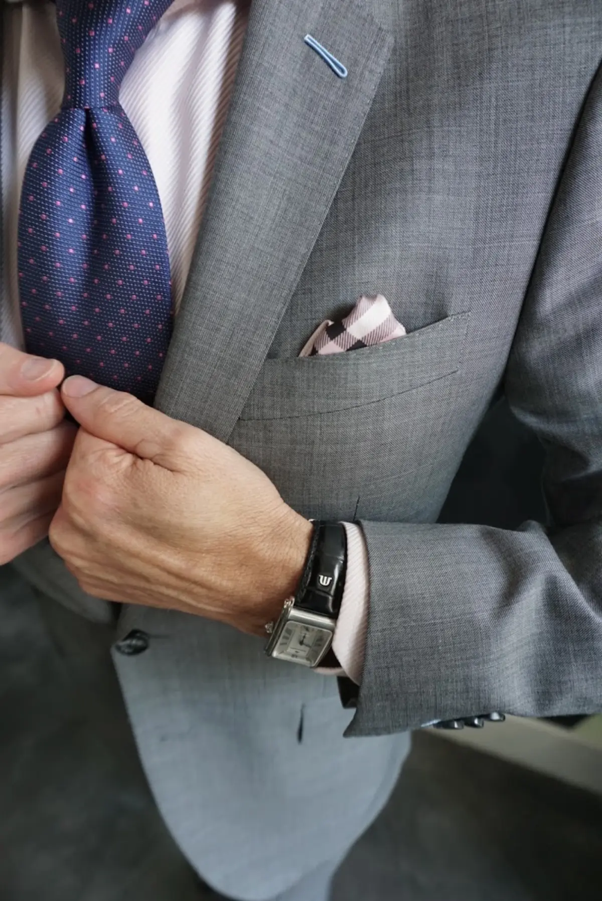 A grey suit with a dotted tie shows the refined detailing available in mid-range custom suiting at Bespoke By CB Miami