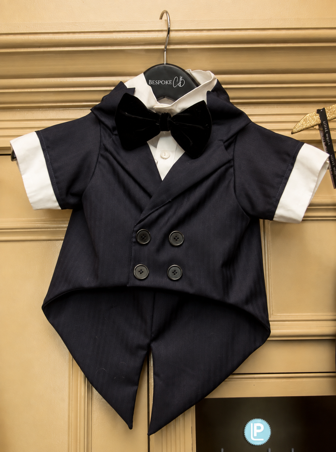 Custom dog tuxedo with navy tails and black velvet bow tie on Bespoke By CB hanger