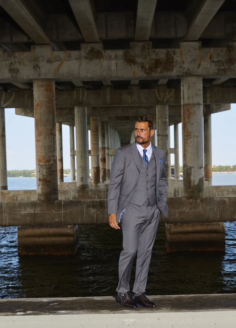 Grey three-piece winter suit with blue tie, the sharp office holiday party look that stays professional.