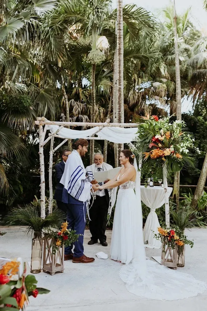 Groomsmen and groom wearing bespoke navy suits during an outdoor tropical wedding ceremony.