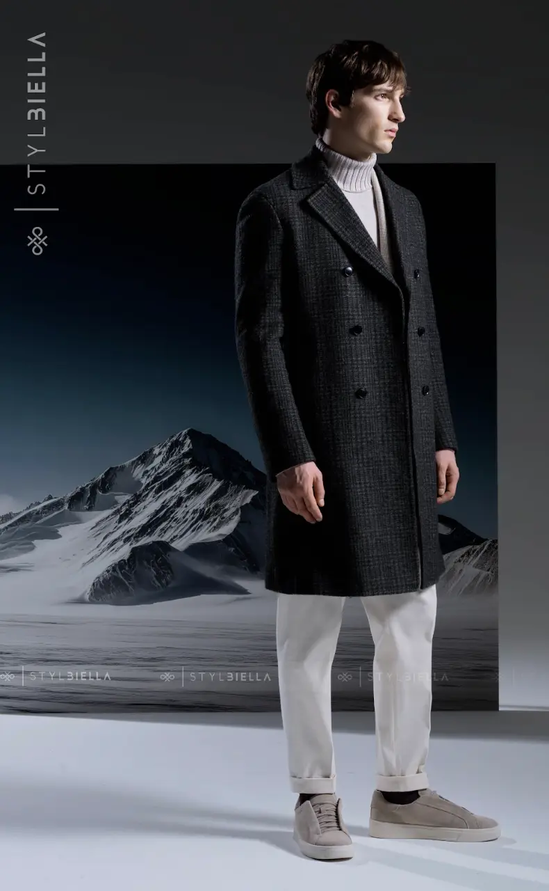 Charcoal micro-check double-breasted overcoat with grey turtleneck and white trousers in mountain setting