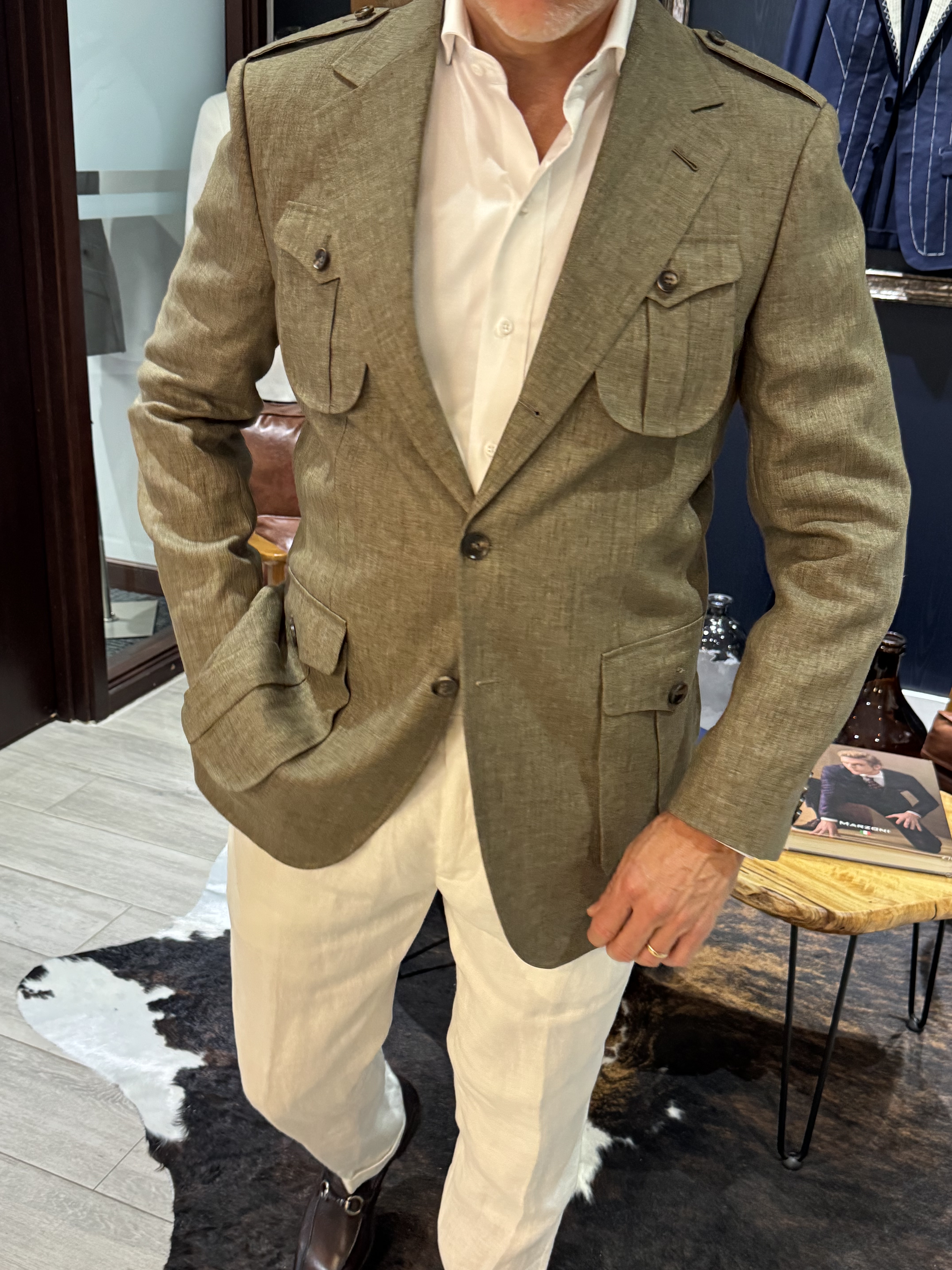 Front view of olive green safari style custom blazer with four pocket layout and epaulettes
