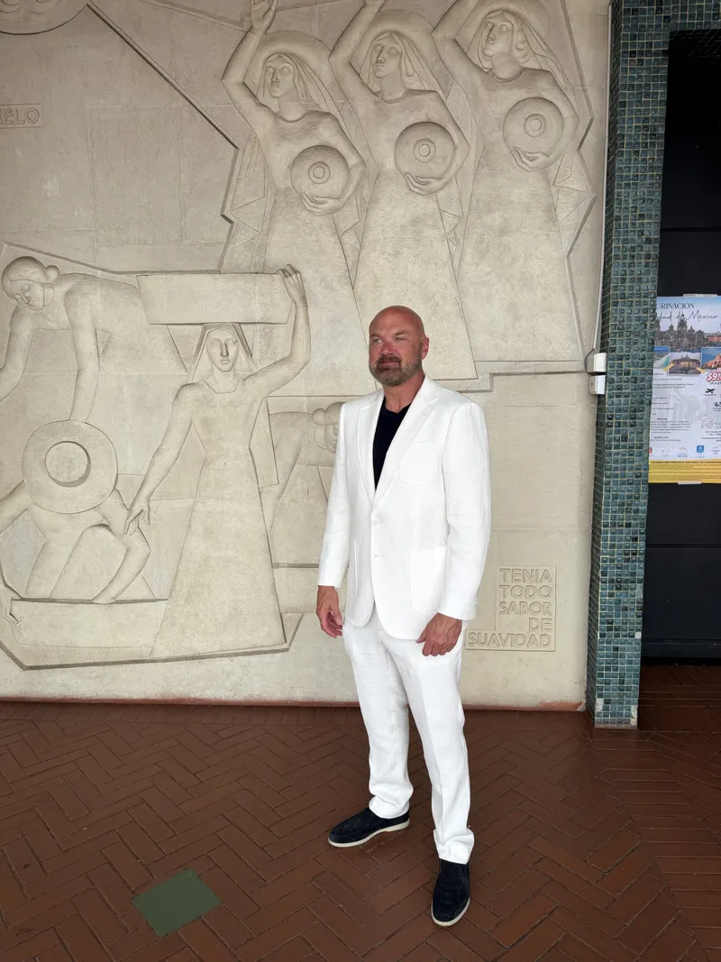 Man wearing a white seersucker suit with black t-shirt, styled for a Miami wedding or summer event by Bespoke By CB