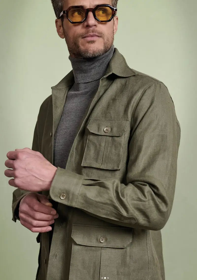 Close-up detail of olive linen shirt jacket showing pocket, buttons, and collar construction