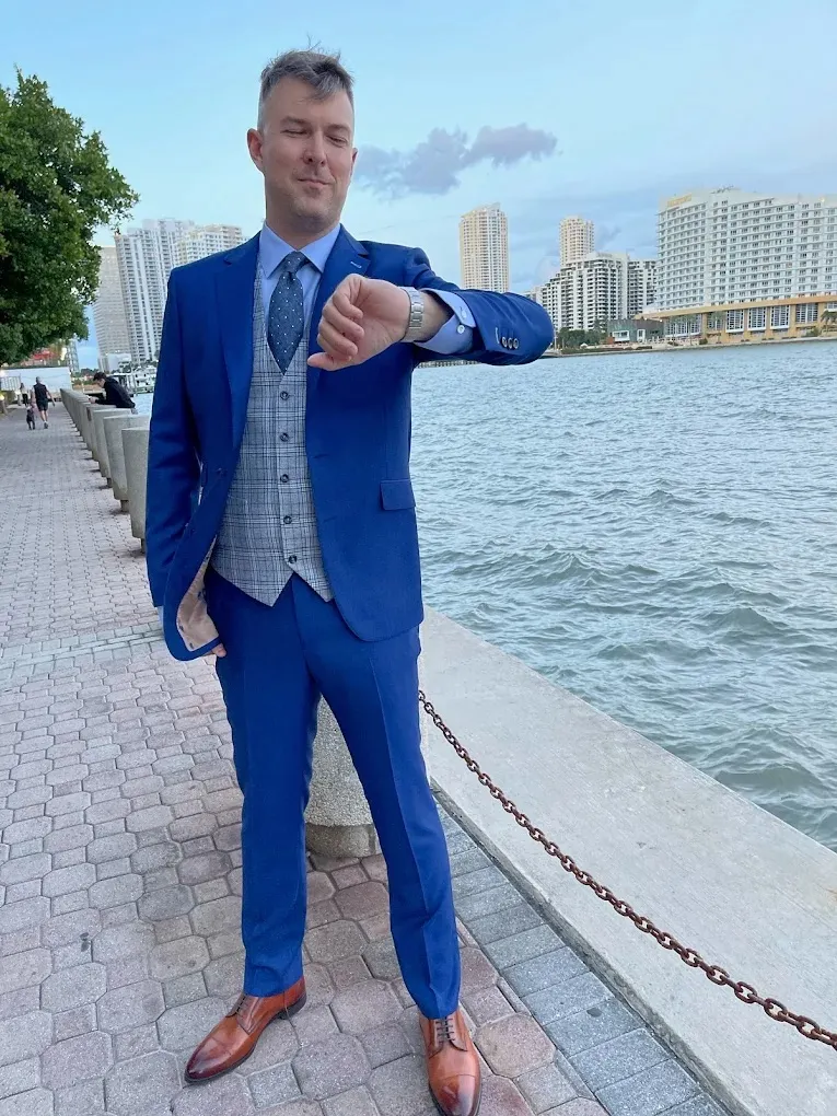 Man standing by the waterfront in Miami wearing a royal blue three piece custom suit.