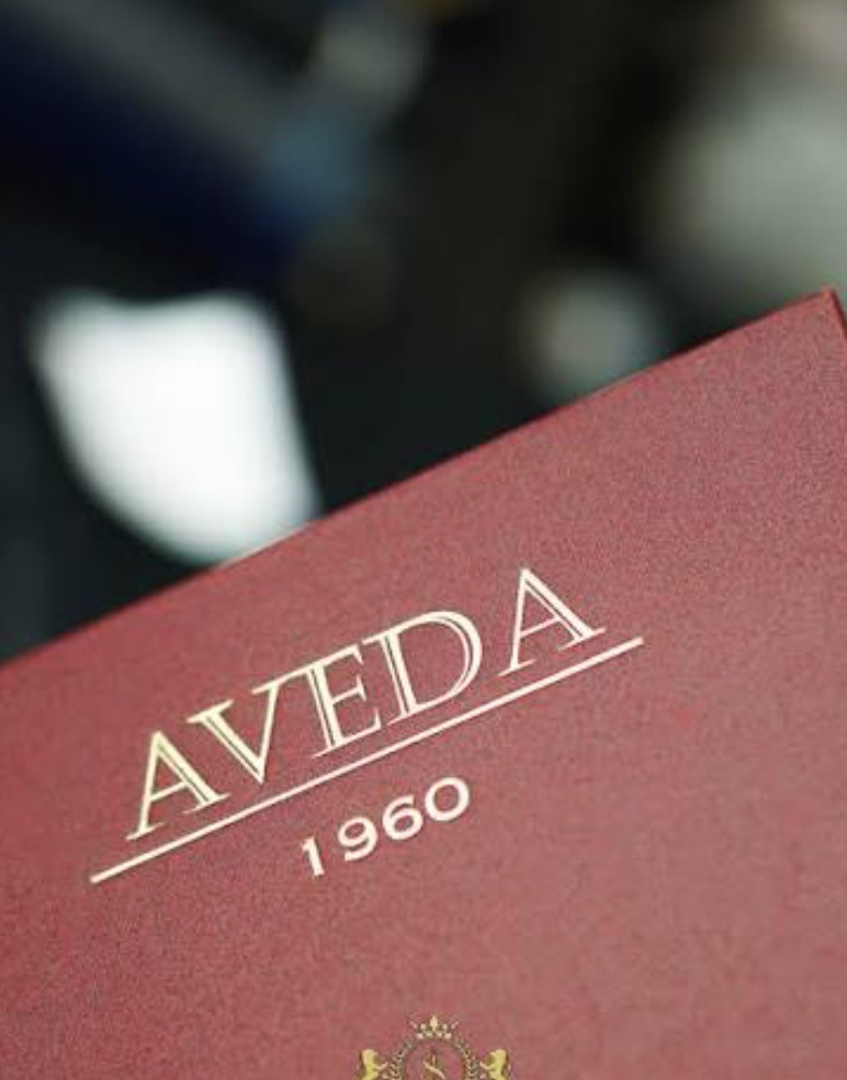 Aveda red sample book showing brand heritage since 1960