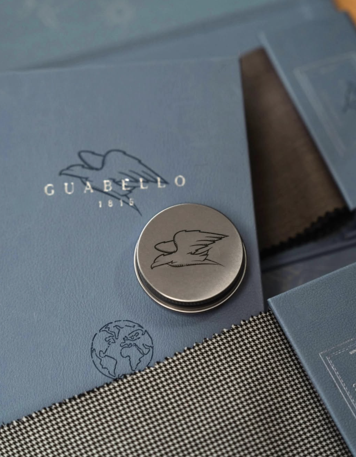 Guabello 1815 blue leather swatch book with eagle logo and metal button