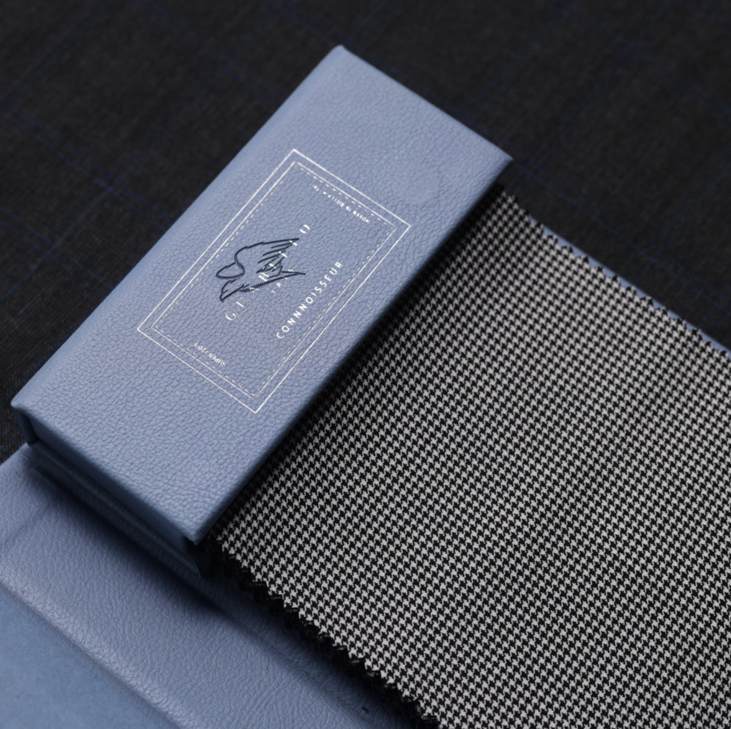 Guabello Connoisseur collection swatch book on houndstooth fabric