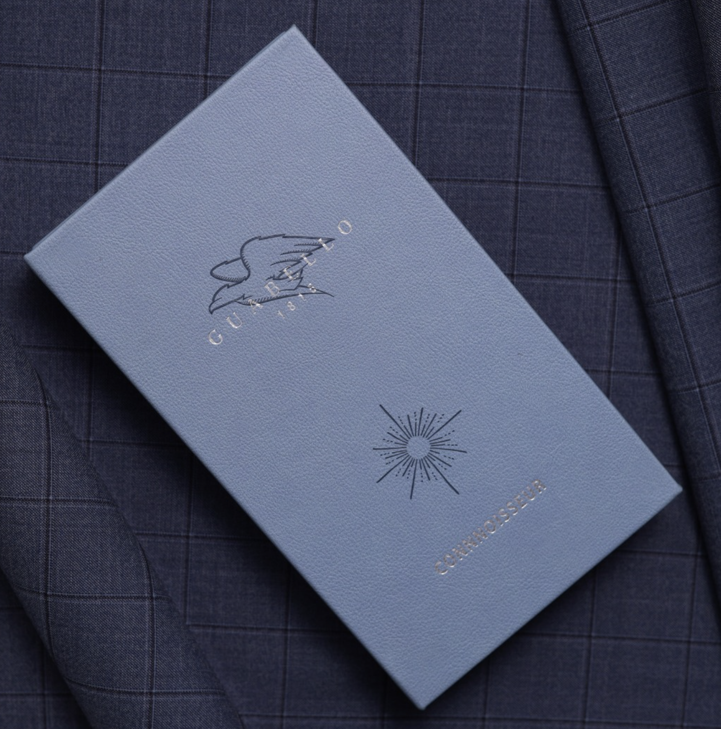Guabello Connoisseur swatch book cover with eagle and sunburst motif
