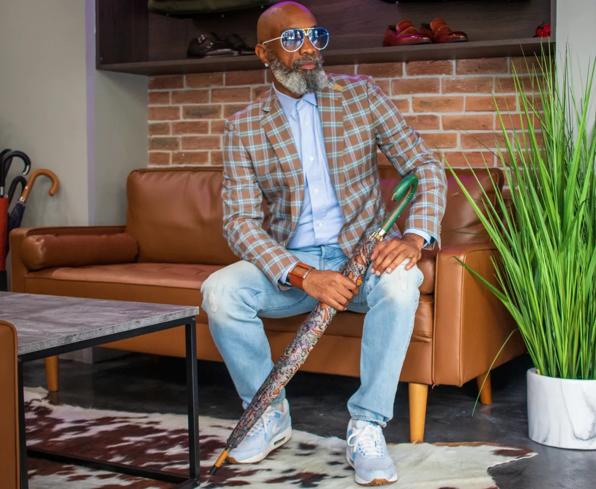Denim trousers styled with a brown plaid blazer and light blue shirt, the dressed up denim chino look for smart casual offices.