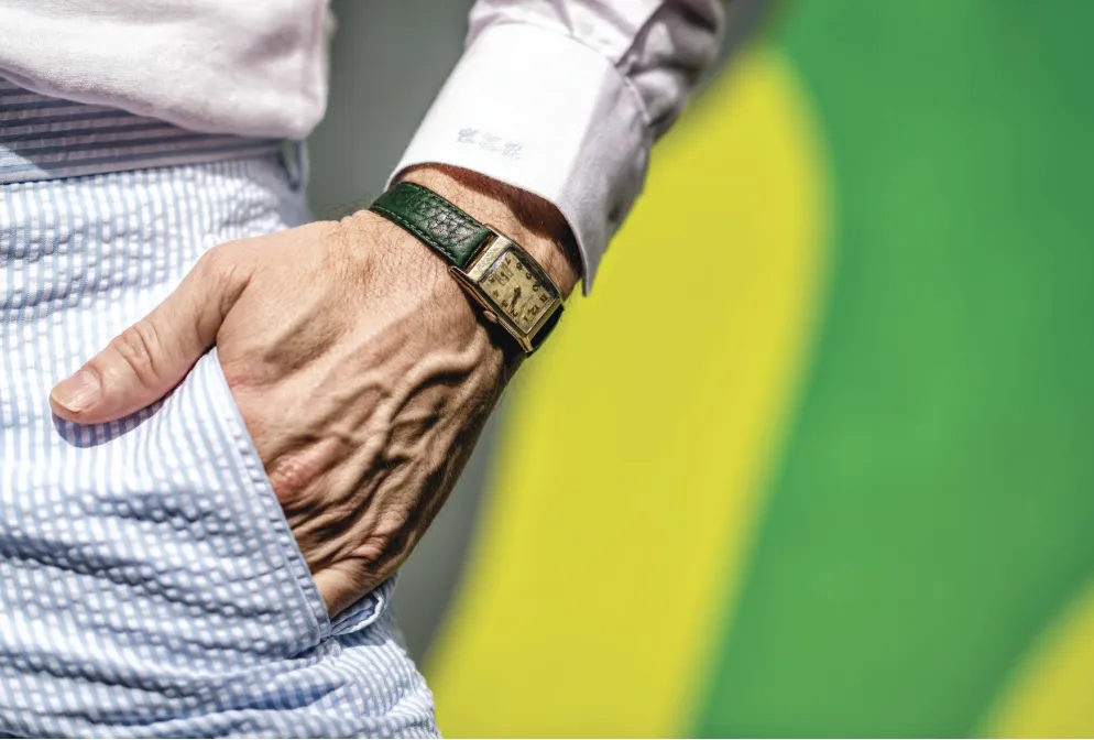 Custom shirt cuff with monogram paired with a vintage watch and seersucker trousers.