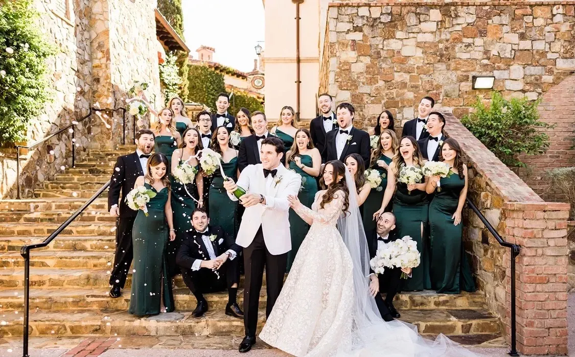 Groom wearing a custom white dinner jacket at an outdoor ceremony, showcasing timeless formal style by Bespoke By CB