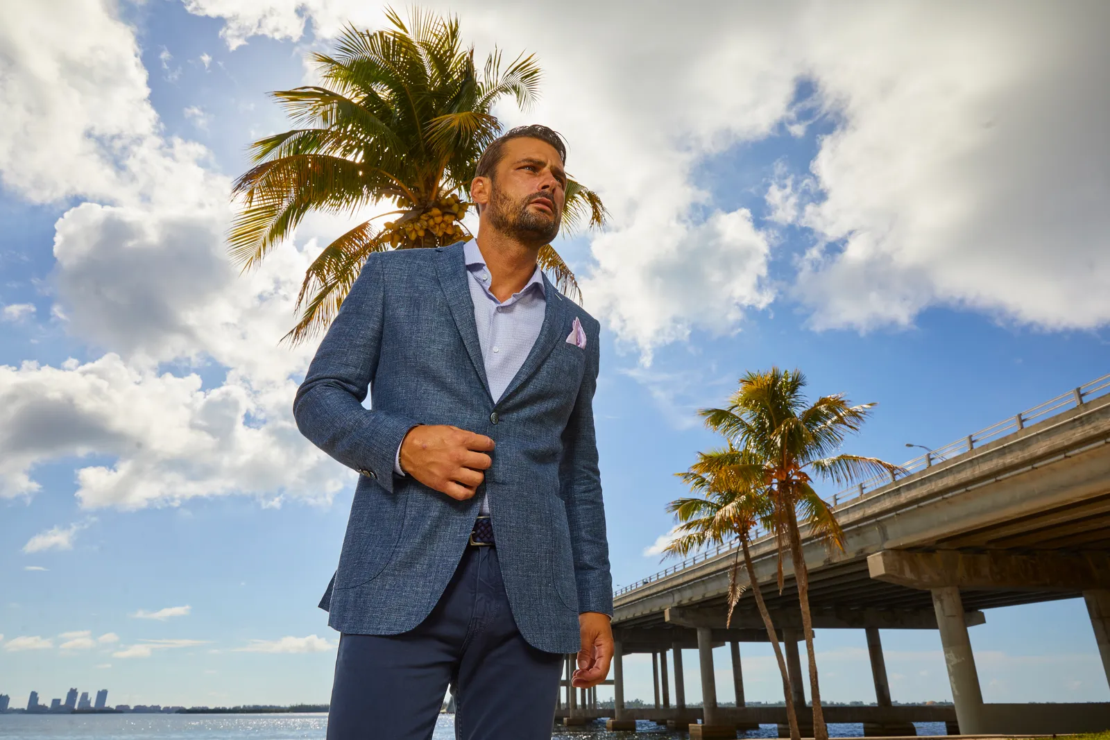 A blue linen textured blazer styled for a warm weather event, representing the kind of versatile piece needed for Miami social occasions.