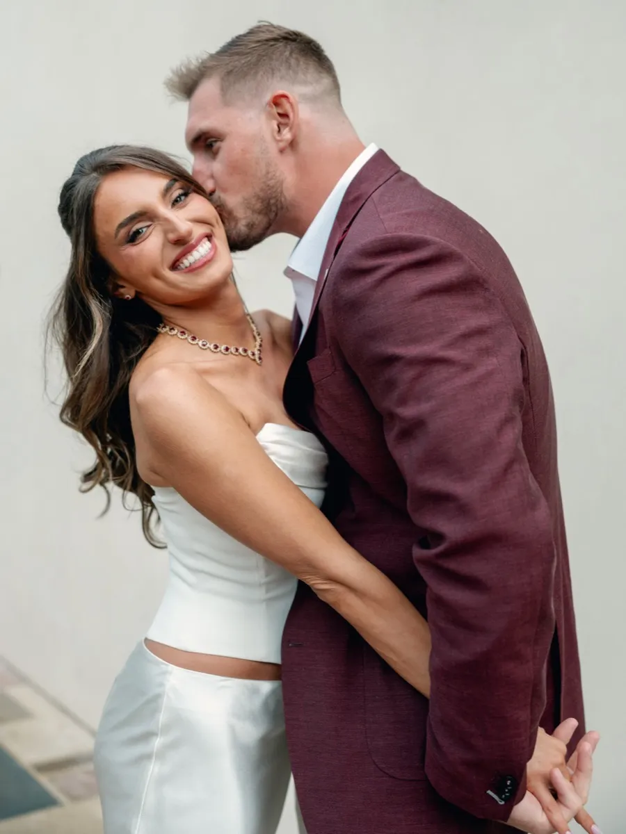 Joey Bosa and Amanda Kassdikian in rehearsal dinner attire sharing a moment, styled from head to toe by Bespoke By CB